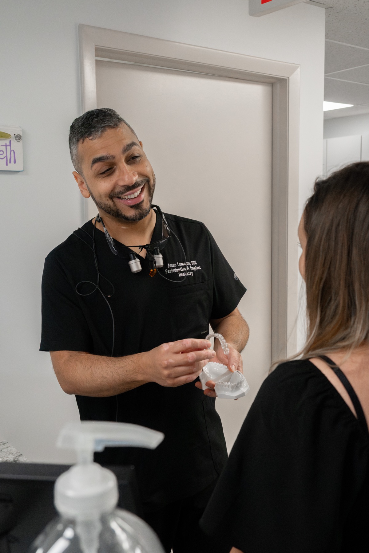 Dr. Jesse Lemoine smiling in clinic, holding a clear aligner tray