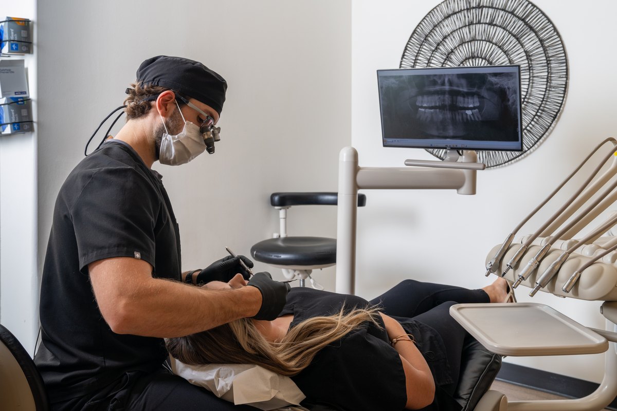 Dr. Kyle Lesko examining a patient chairside at TLC Family Dental Centre in Leduc